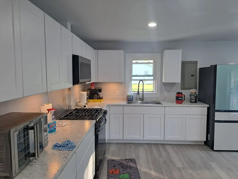 Finished kitchen remodel with white shaker cabinets and quartz countertops